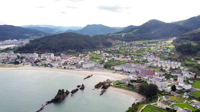 Panoramic aerial view of beautiful country side of Galicia - Spain. View of Covas city, in background is the city of Viveiro. Beautiful landscape with green fields and mountains. Camera track left