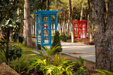 Red and blue booths with benches for relaxing in the park