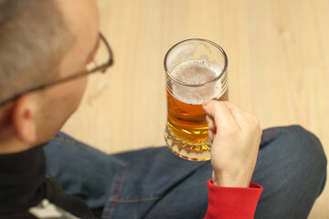 person holding a mug of beer in front of him