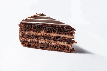 A piece of chocolate cake with cream on a white background.