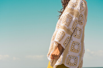 woman on the beach wearing a crochet cardigan made with granny squares, crochet outfit.Outfit...