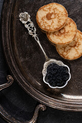 Black Caviar and Pancakes. Top view. Dark blackground.