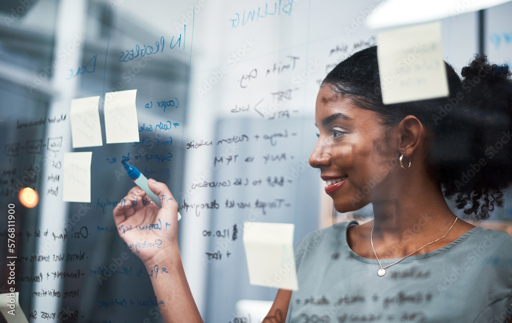 Canvas Prints The expert mind behind an expert plan. Shot of a young businesswoman brainstorming with sticky notes on a glass screen in modern office.