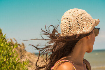 woman on the beach wearing crochet hat .Outfit spring summer