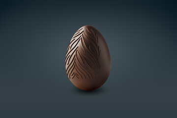 Black milk chocolate easter egg with decorative design on a dark floor
