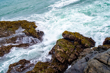 Beautiful tropical landscape. A stone ocean shore with waves and rocks. Beautiful texture background for tourism, design and advertising
