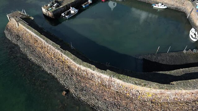 Crail, a historic fishing village on the east coast of Scotland in the East Neuk of Fife. Low level aerial footage of the pretty little harbour. Lovely reflections of whitewashed houses in the water.