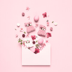 Happy Easter greeting card. Easter decoration explosion treat. Invitation envelope eggs, bunnies, flowers on pink background.