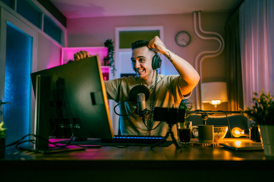 Young man male gamer playing computer game streaming video winning