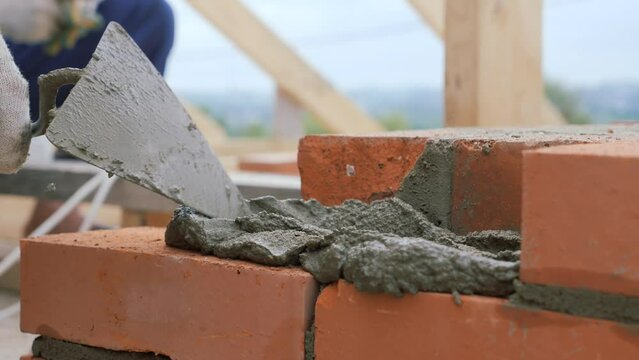 Laying out a brick chimney chimney of a private wooden house.
