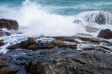 Beautiful tropical landscape. A stone ocean shore with waves and rocks. Beautiful texture background for tourism, design and advertising