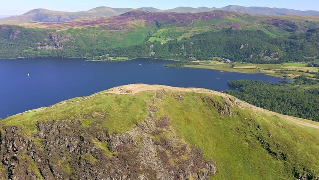 Aerial view of hikers on the summit of a hill overlooking a beautiful lake (Catbells, Lake District)