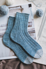 Fototapeta na wymiar Hand knitted socks with needles and yarn balls. Concept for handmade and hygge slow life.