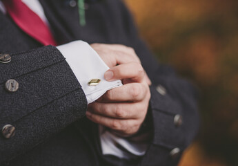 Man or groom buttons up his cufflinks close up - obrazy, fototapety, plakaty
