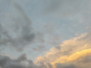 Sky with clouds in twilight. The black clouds and the golden clouds fight for cover the sky