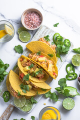The Mexican dish of Taco corn flat cake with vegetable filling on a marble background