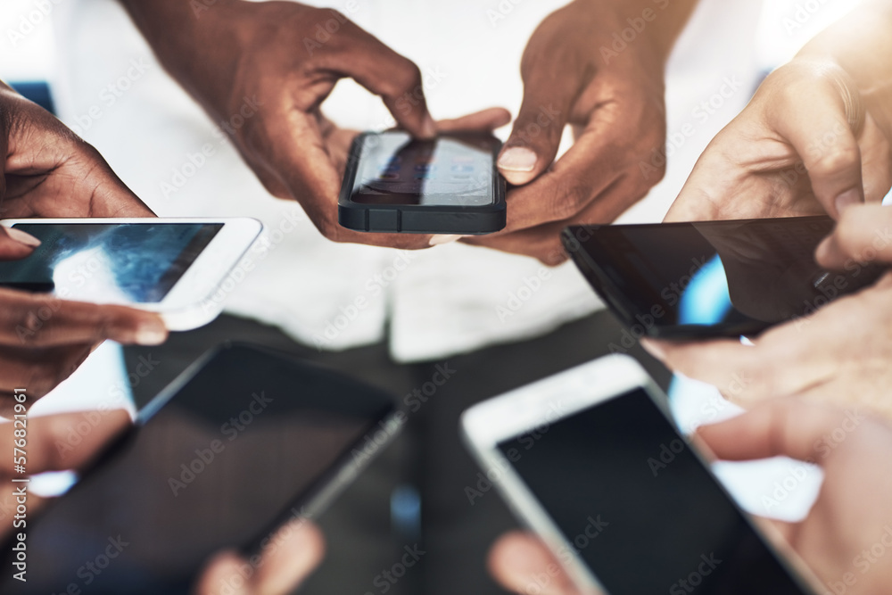Leinwandbilder connecting online and in real time. cropped shot of a group of people using their smart phones in sy