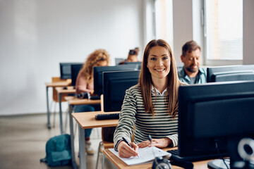 Happy woman attending computer class and looking at camera.