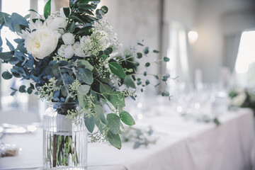 White floral table centre with eucalyptus and flowers at a wedding or party
