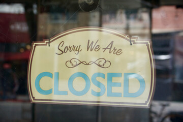 vintage closed sign as seen through the shop window