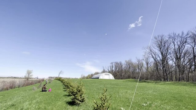 tilt down to little girl controlling a kite string