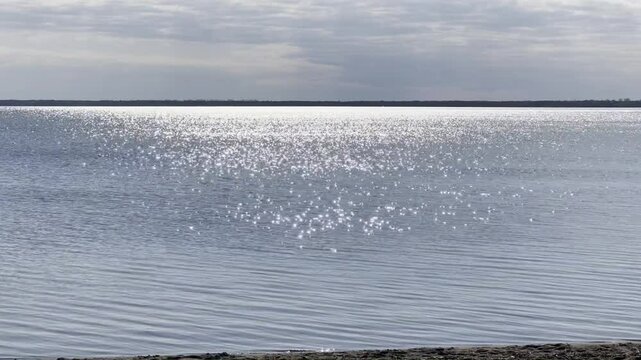 Sunlight glitters like diamonds on a rippling lake