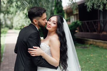 couple in love. stylish Groom in a wedding suit and the bride in a chic white dress. Wedding ceremony.