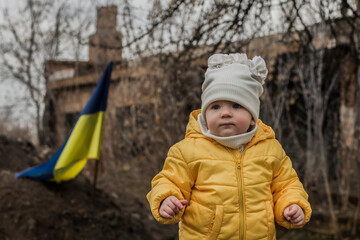 Little girl in front of defensive structures of Ukrainian army. War in Ukraine. Children and war concept. Support for Ukraine. Stop war. .Humanitarian disaster concept. Ukrainian flag