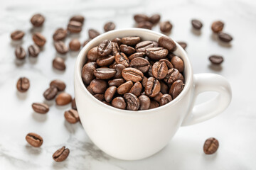 White cup with roasted coffee beans close up, white background. Good mood