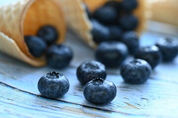 blueberries scattered from a waffle cone on the table. dessert. healthy diet