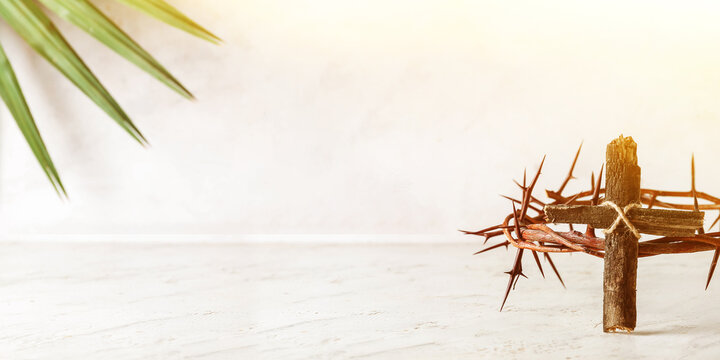 Wooden cross and crown of thorns on light background with space for text. Good Friday concept