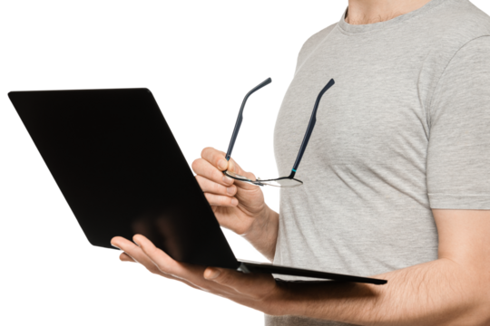 A man holds a laptop in one hand and glasses in the other. Slim ultrabook in matte black with a touch screen. The concept of fatigue from working at the computer.