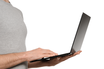 In one hand, a man holds a laptop and the other is typing text on the keyboard. Slim ultrabook in matte black with a touch screen.