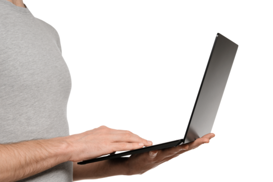 In one hand, a man holds a laptop and the other is typing text on the keyboard. Slim ultrabook in matte black with a touch screen. - Powered by Adobe
