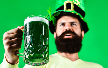 Saint Patricks Day. Green beer with clover. Bearded leprechaun holding mug of green beer pint....