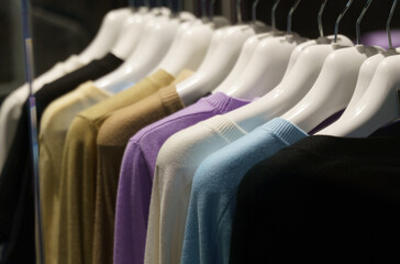 Collection of warm winter women's clothing, jumpers on hangers.