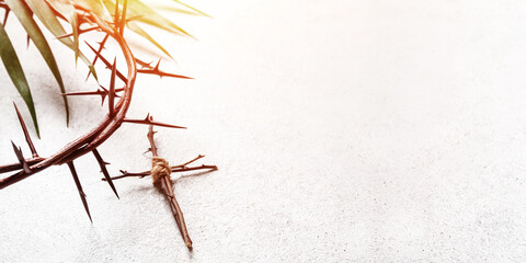 Crown of thorns and wooden cross on light background with space for text, closeup. Good Friday...