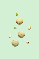 Soft amaretti with pistachios on light green background. Traditional italian almond cookies, Gluten-free bakery. Selective focus, copy space