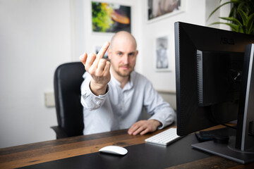 Angry employee shows middle finger in his office/home office after meeting for pitch and continues to make obscene gestures