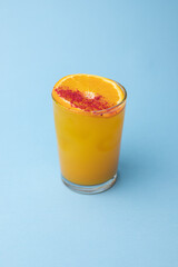 Cocktail on a blue background. Alcohol, party, drink in a beautiful glass.