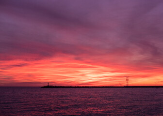 Naklejka na ściany i meble Juicy red sunset in the evening on the sea