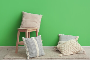 Stylish decorative pillows near green wall