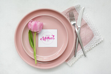 Stylish table setting with beautiful tulip flower for Mother's Day celebration on light background