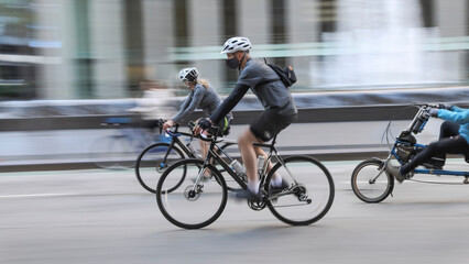 Blurred silhouettes of cyclists on a city street