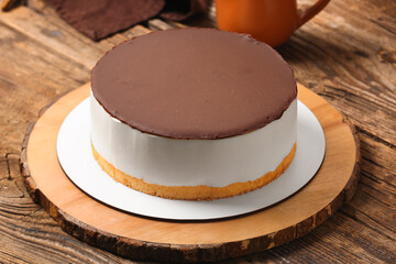 Board with tasty birds milk cake on wooden table