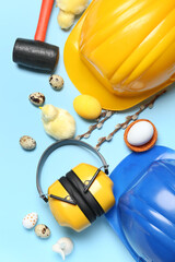 Builder's tools with chickens, Easter eggs and willow branches on blue background