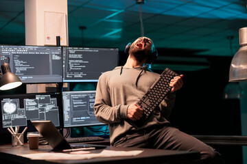 Database programmer playing guitar with keyboard, writing code with cloud computing and programming html source. Cheerful smiling developer having fun and acting silly in office. - obrazy, fototapety, plakaty