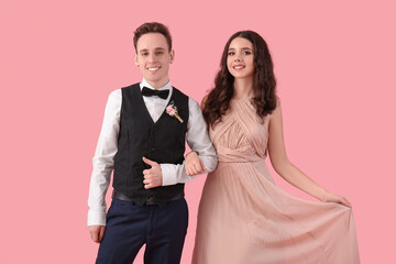 Beautiful couple dressed for prom on pink background © Pixel-Shot