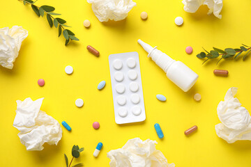Nasal drops with pills, eucalyptus branches and tissues on yellow background. Seasonal allergy...
