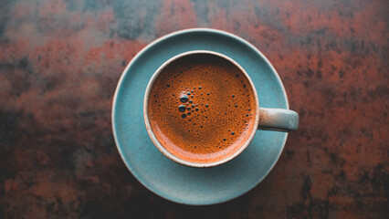 cup of coffee on a table,cup of fresh espresso coffee with interesting perspective, with cup in focus and blurred background